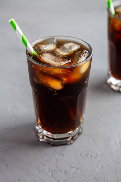 istock Cold Refreshing Dark Cola with Ice Cubes, Straws on a gray background, side view. 1499725868