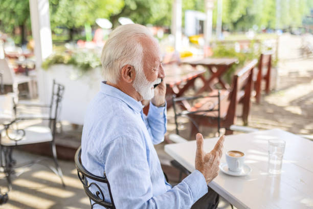istock Senior man relaxing in outdoor cafe using smart phone 1499725872