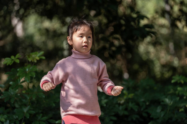 istock A little girl is doing sports operations under a tree 1499728214