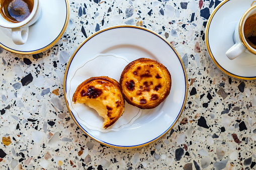 Delicious portuguese pastry named pastel de Belem or pastel de nata typically eaten with expresso coffee, portuguese egg custard tart pastry, optionally dusted with cinnamon,Porto, Portugal