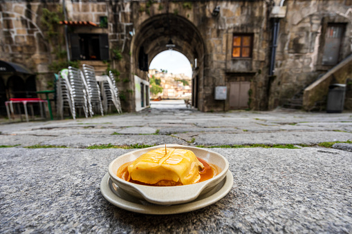 Great view of francesinha typical dish originally from Porto, made with layers of toasted bread and assorted hot meats such as roast, steak, wet-cured ham,melted cheese, Porto, Portugal