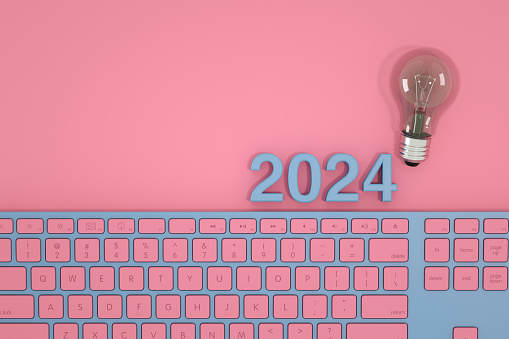2024 new year with computer keyboard and lightbulb on pink background. New idea concept.. Digitally generated image.
