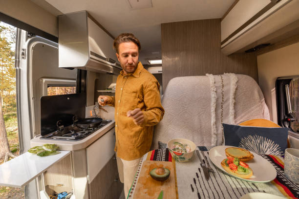 istock Man preparing food inside his camper van. Camping concept 1499730680