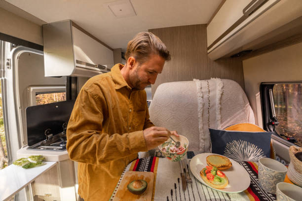 istock Man preparing food inside his camper van. Camping concept 1499730983