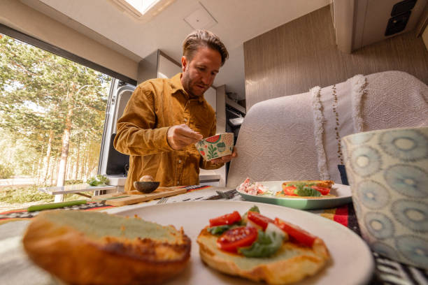 istock Man preparing food inside his camper van. Camping concept 1499730998