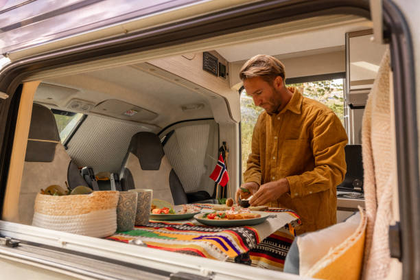 istock Man preparing food inside his camper van. Camping concept 1499731037