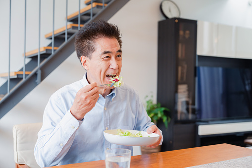 An elderly man enjoying a salad