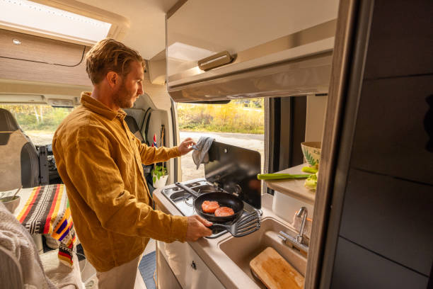 istock Man preparing food inside his camper van. Camping concept 1499731126