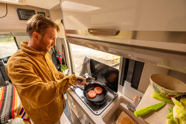 istock Man preparing food inside his camper van. Camping concept 1499731183