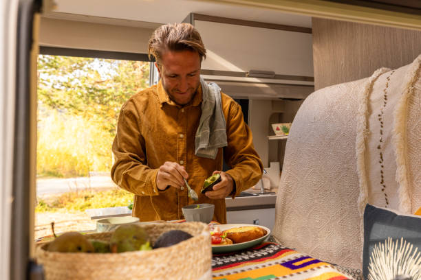 istock Man preparing food inside his camper van. Camping concept 1499731300