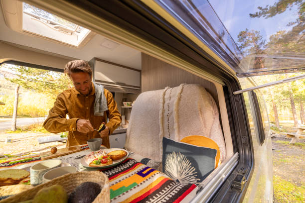 istock Man preparing food inside his camper van. Camping concept 1499731313