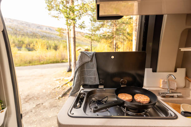 istock A camping stove with a pan and two salmon steaks, Preparing food inside camper van. Camping concept 1499731332