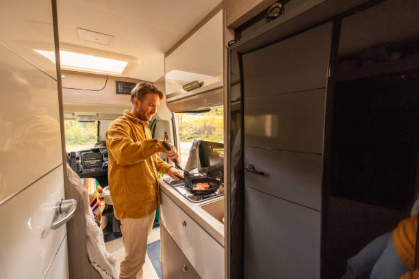 istock Man preparing food inside his camper van. Camping concept 1499731519