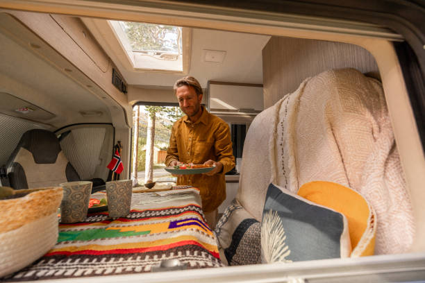 istock Man preparing food inside his camper van. Camping concept 1499731667