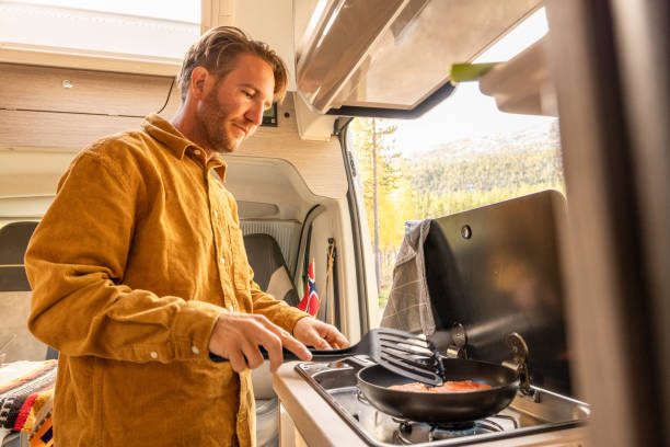istock Man preparing food inside his camper van. Camping concept 1499731733