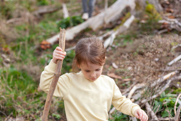 istock Cute little girl with a stick in the forest. Selective focus. 1499732518