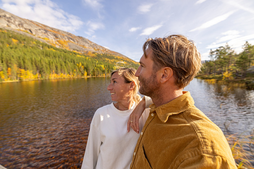 Couple enjoying peaceful environment in Norway. Lake and green mountains.\nThey love their beautiful vacation in the nordic countries.