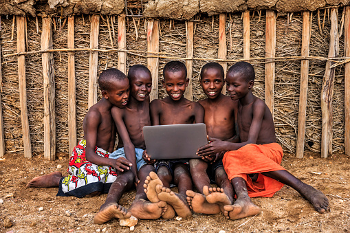 Group of African children, from Samburu tribe, using laptop in the village, Kenya, East Africa. The Samburu tribe is one of the more dominating tribes of north-central Kenya