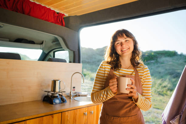 istock Woman in apron drinking coffee in  the camper van 1499734641