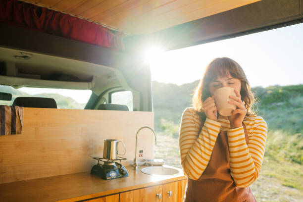 istock Woman in apron drinking coffee in  the camper van 1499734644