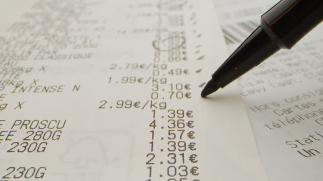 close-up of travelling euro till receipts with a pen checking prices