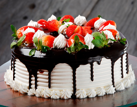 Cake with white chocolate icing, whipped cream and strawberries