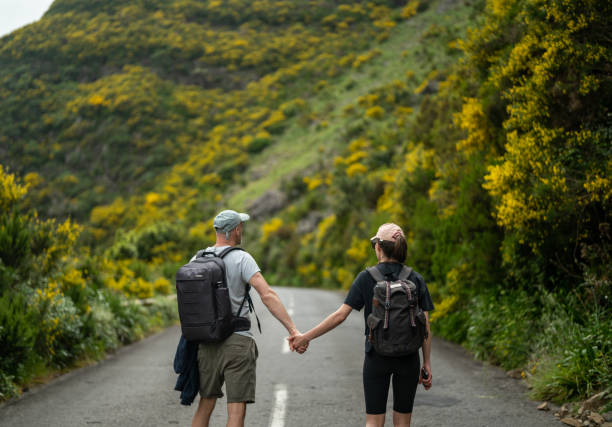 Tourists enjoying tropical climate and walking down a road holding hands together stock photo