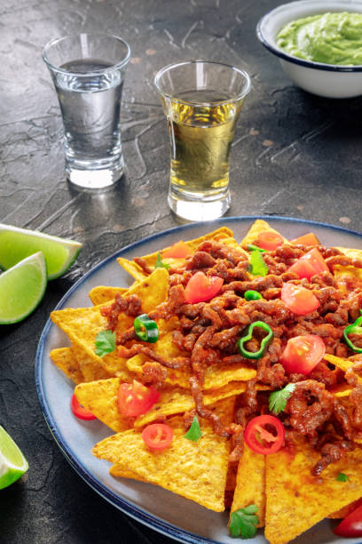 istock Nachos, Mexican food, tortilla chips with beef and fresh vegetables 1499736995