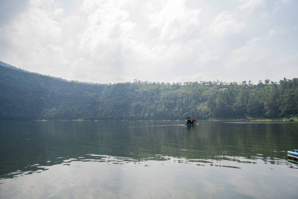 istock the tropical lake with cloudy vibes, going around with traditional boat. 1499738207