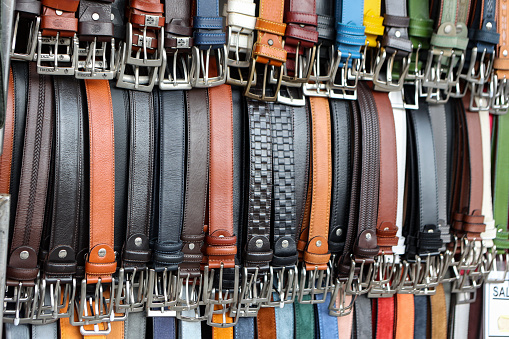 Large group of leather belts in a store.