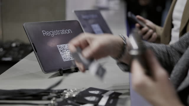 Close up shot of business people using smartphone to read the registration QR-code.