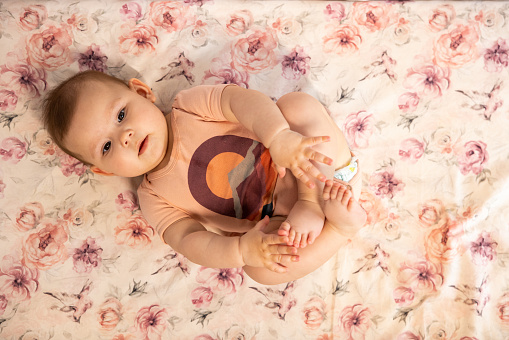 High angle view of adorable Caucasian baby girl, lying down in baby crib