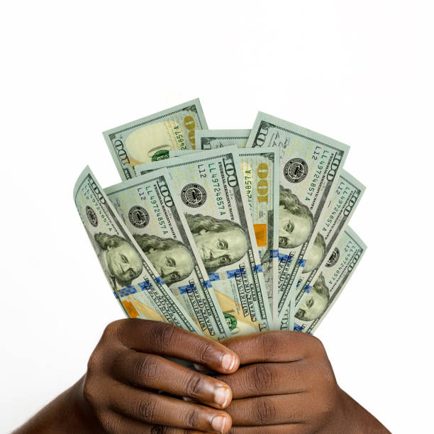 istock Black hands holding 3D rendered 100 us dollar notes. closeup of Hands holding dollar bills 1499750470