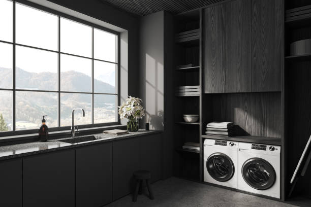 istock Grey interior of laundry room with washing machine and iron table, window 1499750820