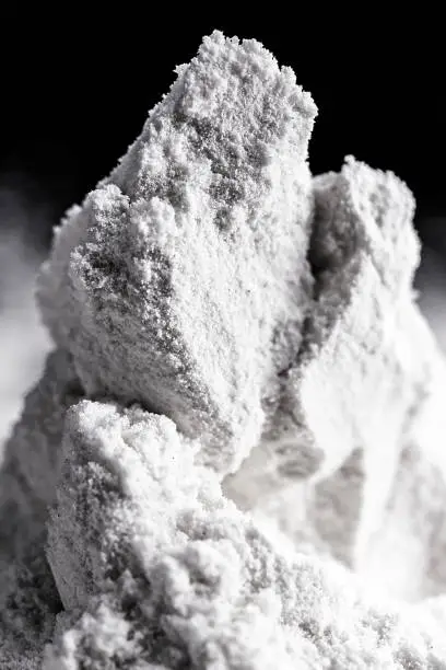 Photo of Kaolin on isolated black background, is an inorganic mineral, chemically inert, used in several branches of industry, from cosmetics to dye