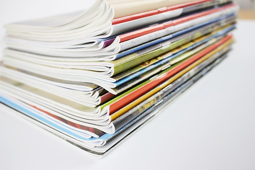 Stack of colorful magazines, extremely covers. Side View