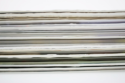 Stack of colorful magazines , extremely sheets. Side View.