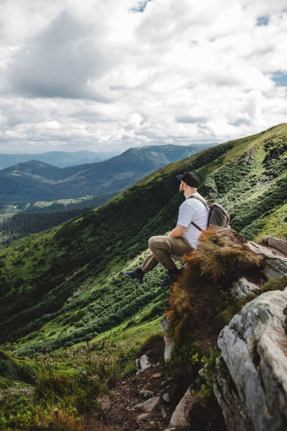 istock Man on top of a mountain sitting on a rock 1499754043