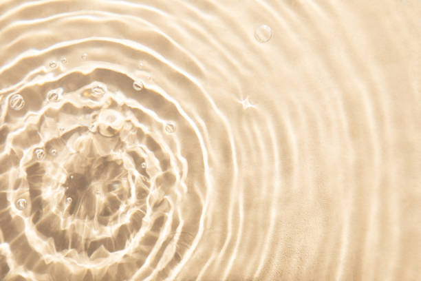 istock Abstract textured background, water waves in the pool with sun reflection, clear beige water 1499757142