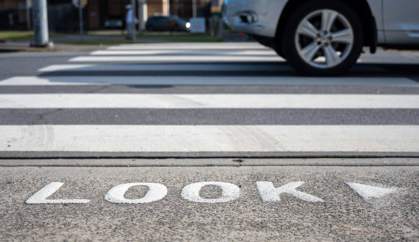 オーストラリアのシドニーの通りの横断歩道、警告語横断前に歩行者が道路に注意を向け続けるために通りを見てください