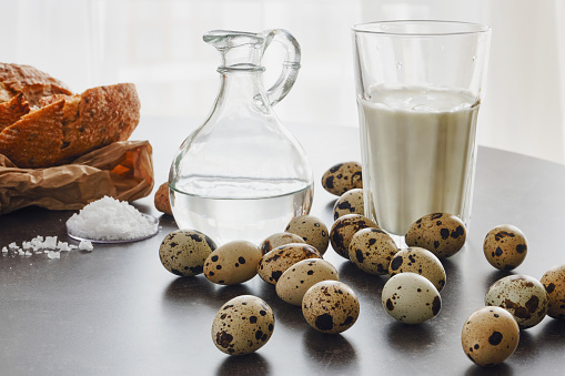 Group of quail eggs with bread, flour, salt, glass of a milk. Shallow depth of field