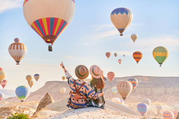 couple romantique heureux voyageant ensemble et fait vœu dans la vallée pittoresque de l’anatolie, kapadokya. belle destination à nevsehir, göreme - color image people air vehicle airplane photos et images de collection