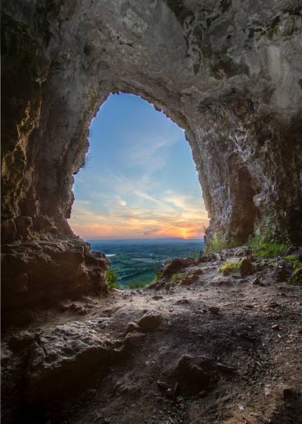 istock Vertical of sunset over a landscape seen from a cave 1499762588
