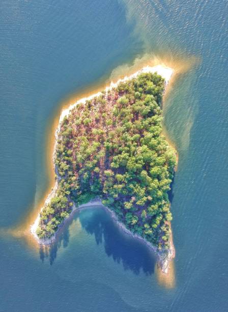 istock an island with trees is shown in the water at sunset 1499763582