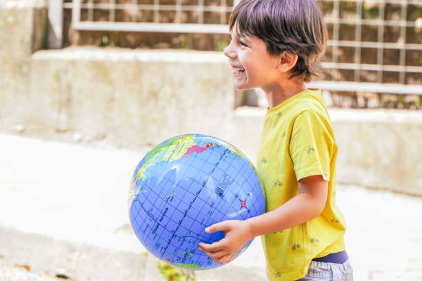istock Happy oy playing with earth globe at the school yard 1499763590