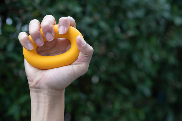 istock Hands of a man squeezing a green stress ball. 1499764222