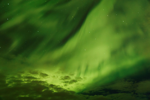 Strong Northern Lights (Aurora Borealis) swirling directly overhead in Labrador, Canada. Nigh sky and stars visible in background.