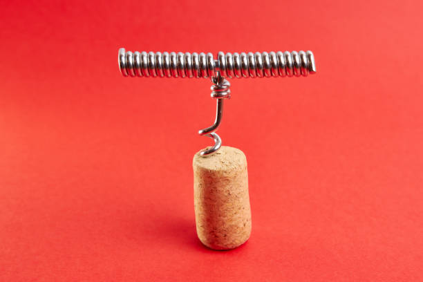 istock Metal corkscrew screwed into a wine cork on a red background. 1499768678