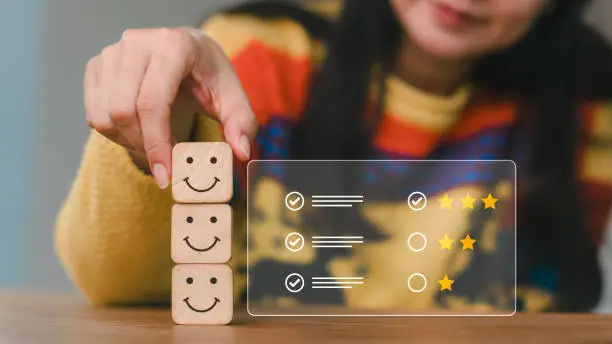 Photo of Concept of mental and emotional well-being; a happy face is displayed on the face of a wooden block cube to represent a good outlook.