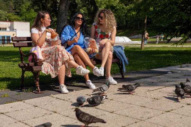 istock The girls (friends) are eating popcorn while sitting on the bench. 1499770764